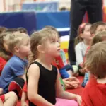 Kinder in einer Sporthalle vor einem Bewegungsspiel im Kindergarten
