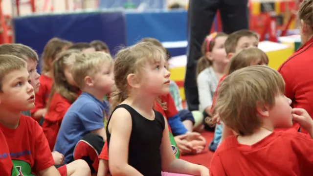 Kinder in einer Sporthalle vor einem Bewegungsspiel im Kindergarten