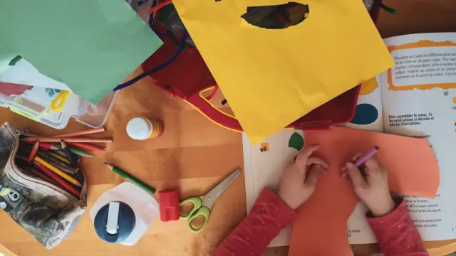 Kinderhände bei einer herbstlichen Bastelaktivität als Inspiration für Fingerspiele